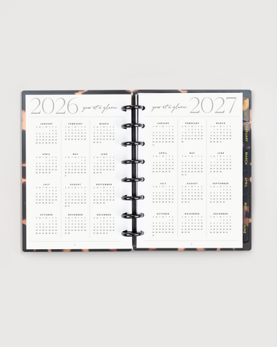 Open planner showing calendar pages from 2026 to 2027 on a white background